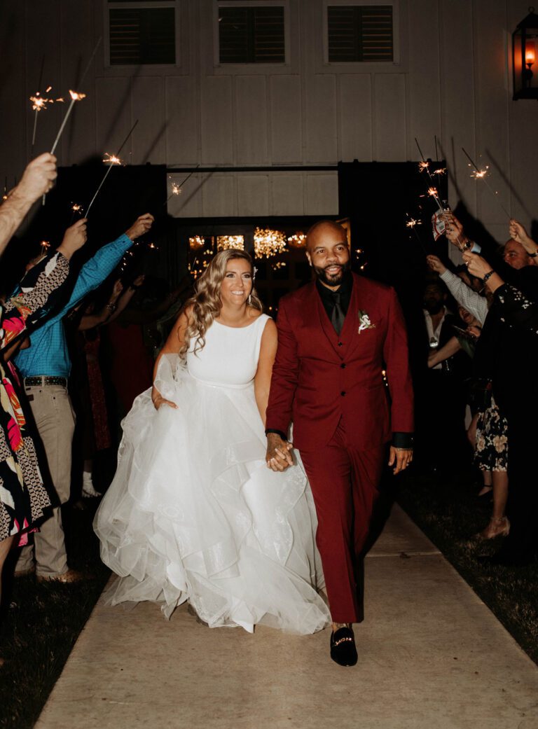 A charming wedding exit with guests waving sparklers, creating a magical send-off for the newlyweds.