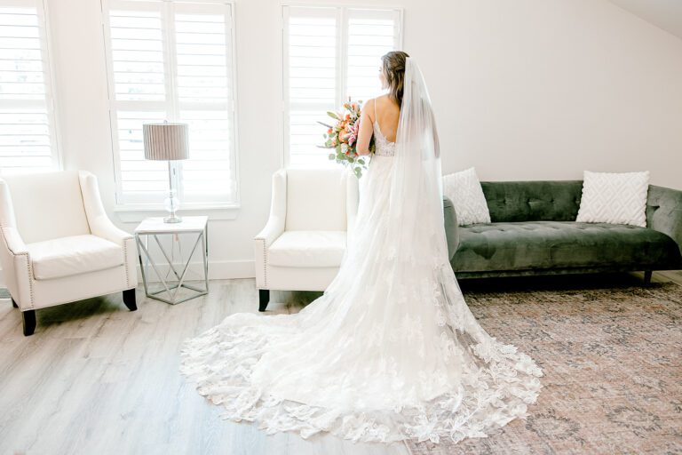 A romantic wedding dress holding a giant floral bouquet.