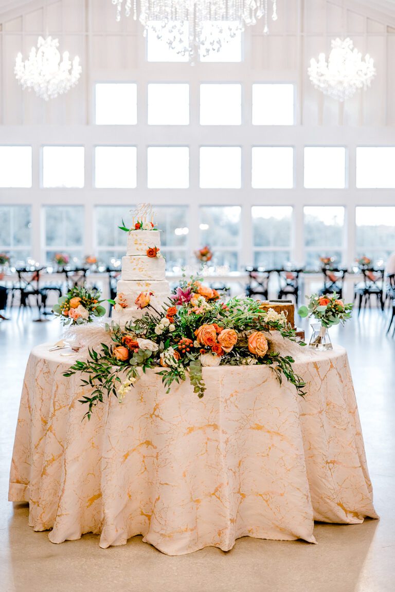 Wedding cake table with beautiful flowers and foliage.