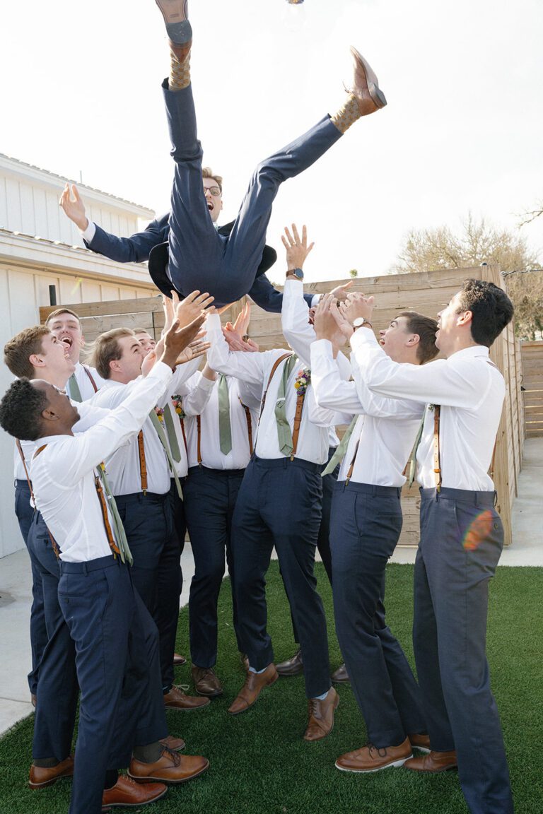 A joyful groom getting ready with his groomsmen, sharing laughter and camaraderie.