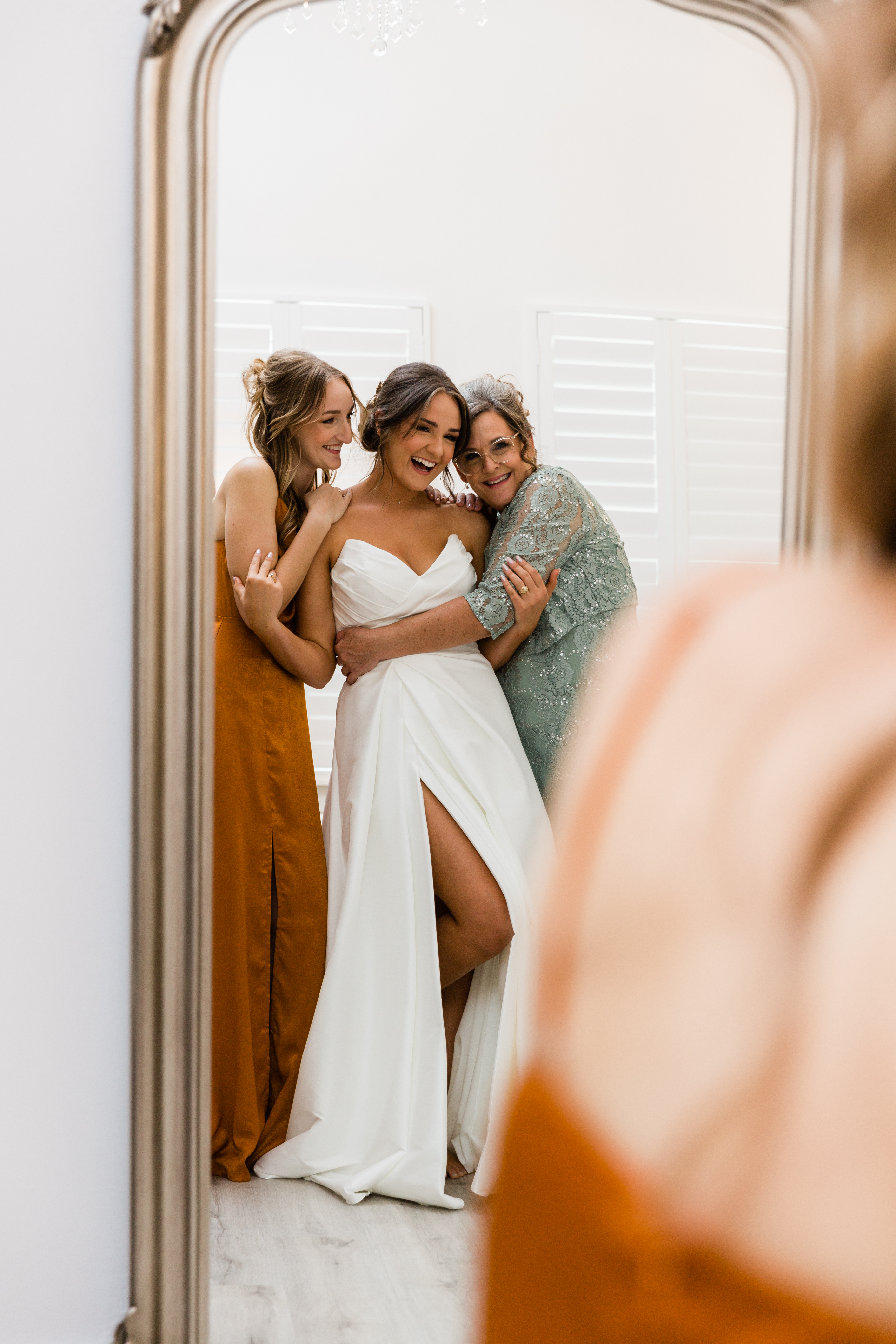 A group of bridesmaids admiring the bride's wedding dress in anticipation of the ceremony.