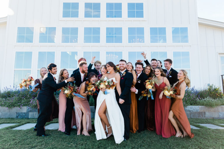 A joyful wedding party posing for a playful and candid photo, showcasing their camaraderie.