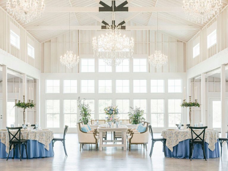 Beautiful blue wedding colors in a bright and airy wedding venue with chandeliers.