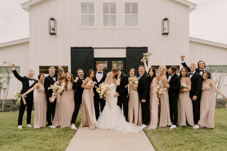 A beaming bride and groom surrounded by their enthusiastic wedding party.