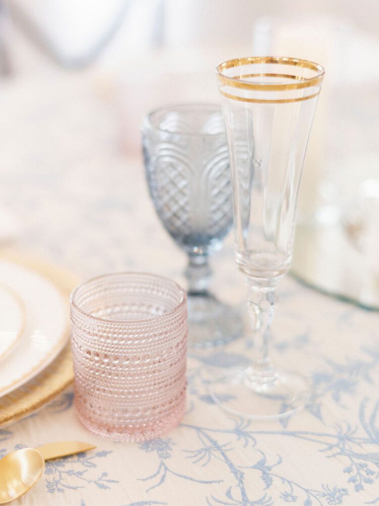 Pink, blue, and gold-rimmed glassware for a wedding table reception.